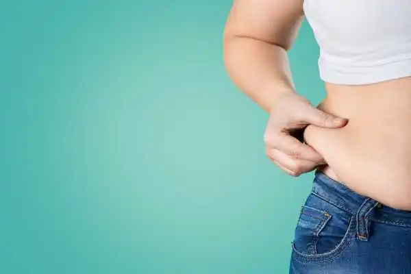 Image of woman pinching her love handles to show weight gain Isleworth